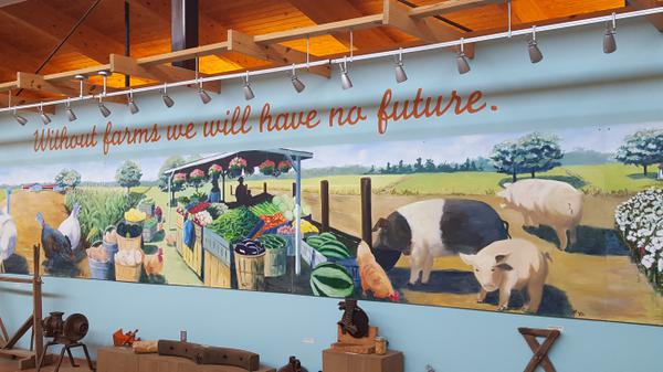 Mural featuring pigs and vegetable stand with text: "Without farms we will have no future"